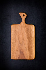 Handmade walnut chopping block on black wooden board