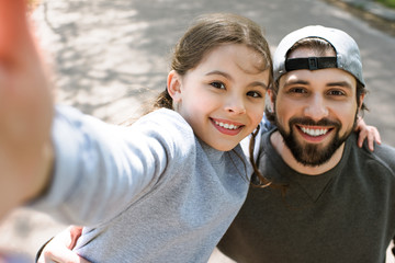 daughter taking selfie smiling father in park