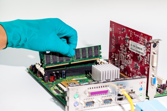 The technician is putting the RAM on the socket of the computer motherboard.