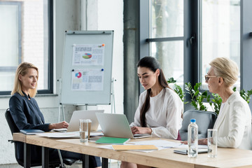 beautiful businesswomen using laptops at meeting in office