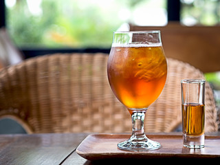 Summer drink, ice lemon brewing tea with syrup served in wooden plate on wooden table at beach hotel for relax and vacation on summer