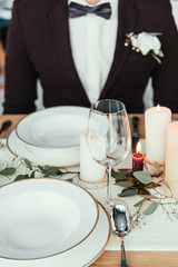 partial view of groom sitting at served table, rustic wedding concept