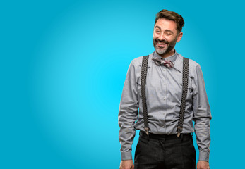 Middle age man, with beard and bow tie blinking eyes with happy gesture