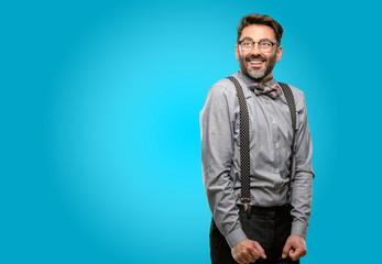 Obraz premium Middle age man, with beard and bow tie confident and happy with a big natural smile laughing looking up