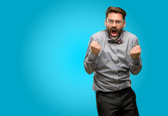 Middle age man, with beard and bow tie happy and excited celebrating victory expressing big success, power, energy and positive emotions. Celebrates new job joyful