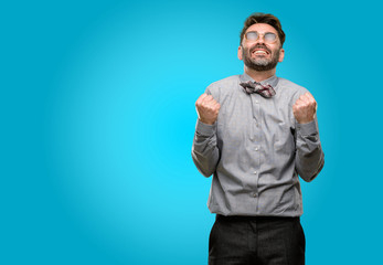 Middle age man, with beard and bow tie happy and excited celebrating victory expressing big success, power, energy and positive emotions. Celebrates new job joyful