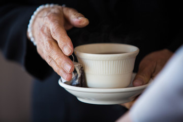 Elderly Hands Holding Coffee Mug