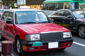 Details of red taxi cars out of service on the street with chinese language. A Hong Kong taxi is...