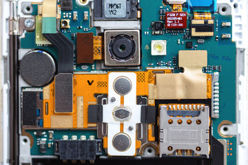 Fototapeta premium Disassembled mobile phone or smartphone on repair without a back cover, printed circuit board, microcircuit, slots for sim cards