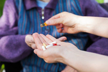 Elderly ill woman receiving pills