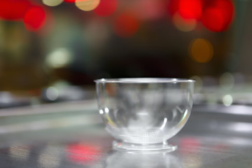 Empty plastic cup for a sweet ice cream dessert on a background of bright glare.