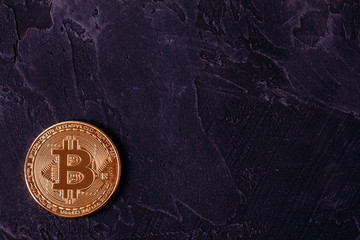 Golden Bitcoin on a concrete dark background with copy space
