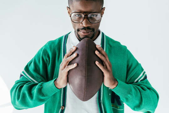 handsome african american man holding rugby ball, isolated on white