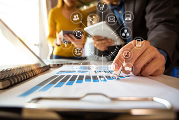 Working team meeting concept,businessman using smart phone and laptop and digital tablet computer in modern office with virtual interface icons network diagram at modern office in morning light
