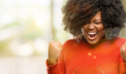 Beautiful african woman happy and excited celebrating victory expressing big success, power, energy and positive emotions. Celebrates new job joyful, outdoor - Powered by Adobe