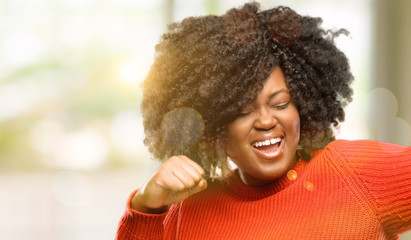 Beautiful african woman happy and excited celebrating victory expressing big success, power, energy and positive emotions. Celebrates new job joyful, outdoor