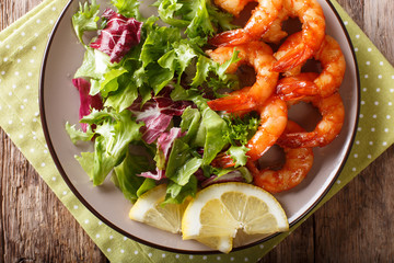 Honey soy king prawns and fresh salad close-up on a plate. horizontal top view