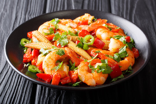 Freshly prepared Mexican prawns with sweet peppers, chili, garlic, corn cobs and herbs close-up. horizontal