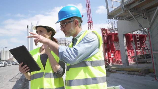 Construction manager and engineer working on building site