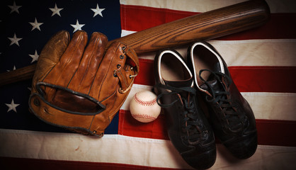 A group of vintage baseball equipment, bats, gloves, baseballs American flag background