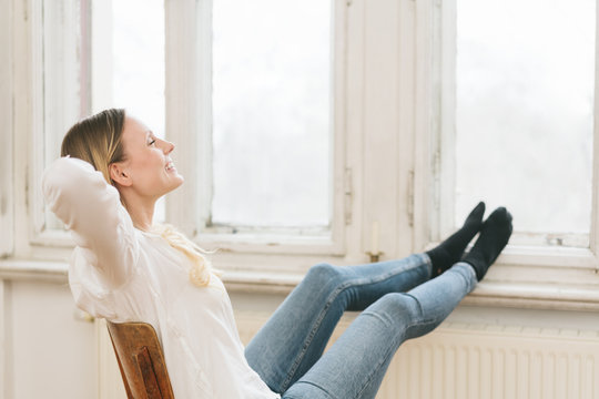 Happy young woman relaxing with her feet up