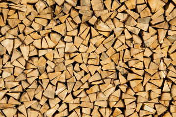 Dry chopped firewood logs ready for winter as background or texture.