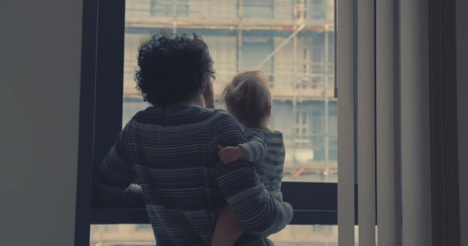 Father with toddler at window in the city