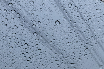 Rain drops on the windshield with wires.