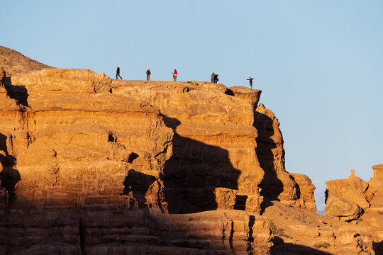 Tourists walk and take pictures on the background of Charyn canyon in Kazakhstan