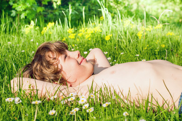 Cute little boy lies on the grass