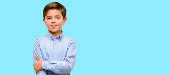 Handsome toddler child with green eyes confident and happy with a big natural smile laughing over blue background