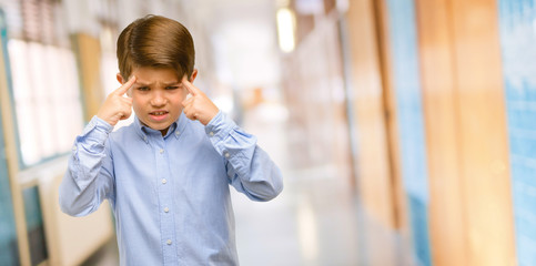 Handsome toddler child with green eyes doubt expression, confuse and wonder concept, uncertain future at school corridor