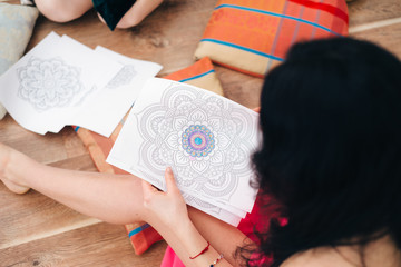 High angle view of young girl looking through sheet album at home