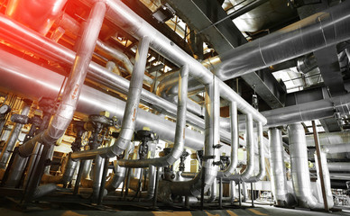 Equipment, cables and piping as found inside of a modern industrial power plant. Industrial zone, Steel pipelines, valves, cables and walkways