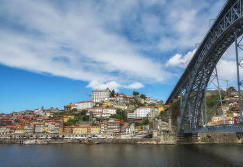 Fototapeta na wymiar View of colorful old houses of Porto from under the Dom Luis Bridge. Douro River. Porto, Portugal.