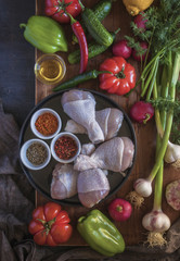 Marinated picnic meat with different vegetables and greens on wooden Board. Top view.