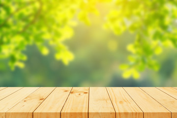 Naklejka na ściany i meble Wood floor with blurred trees of nature park background and summer season, product display montage
