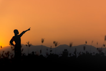 Fototapeta na wymiar Silhouette happy woman standing on a sunset