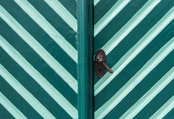 The old and painted wooden door in turquoise