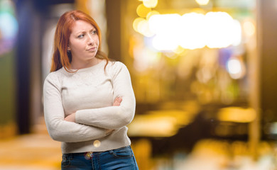 Beautiful young redhead woman irritated and angry expressing negative emotion, annoyed with someone at night