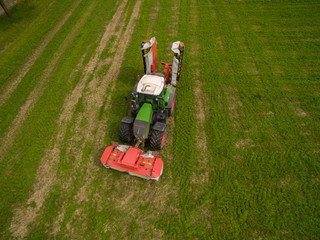
modern tractor working on the agricultural field - tractor plowing and sowing in the agricultural field - aerial view - high top view