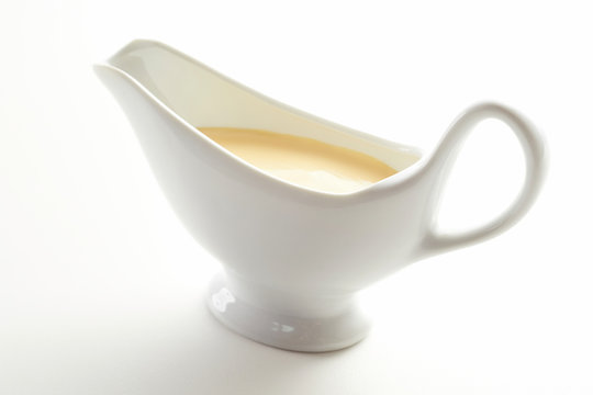 Sauce boat filled with gourmet Hollandaise sauce