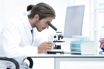 Fototapeta na wymiar Male Chemist Scientific Reseacher using Microscope in Laboratory