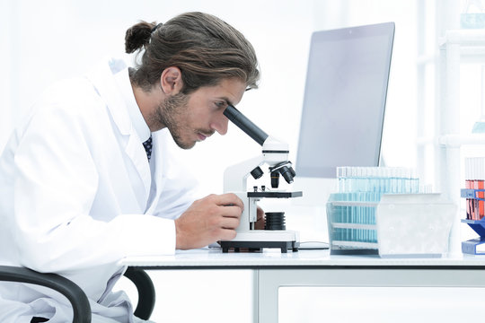 Male Chemist Scientific Reseacher using Microscope in Laboratory