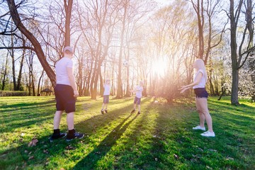 Family playing with ball on grass meadow.