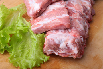 Raw Ribs on a rustic cutting board with salt, pepper and grinder for spices . copy space. Top View.