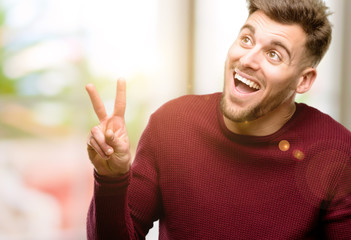 Handsome young man happy and excited expressing winning gesture. Successful and celebrating victory, triumphant