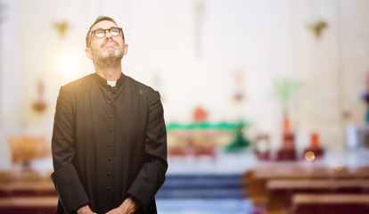 Priest religion man thinking and looking up expressing doubt and wonder at church