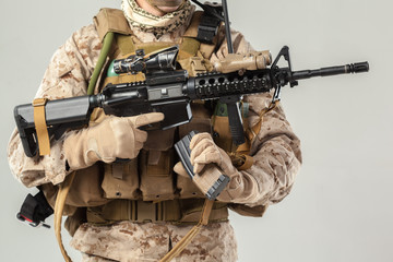 Soldier in camouflage holding rifle