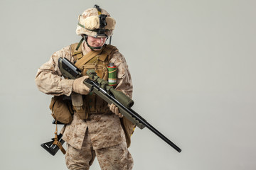 Soldier in camouflage holding rifle